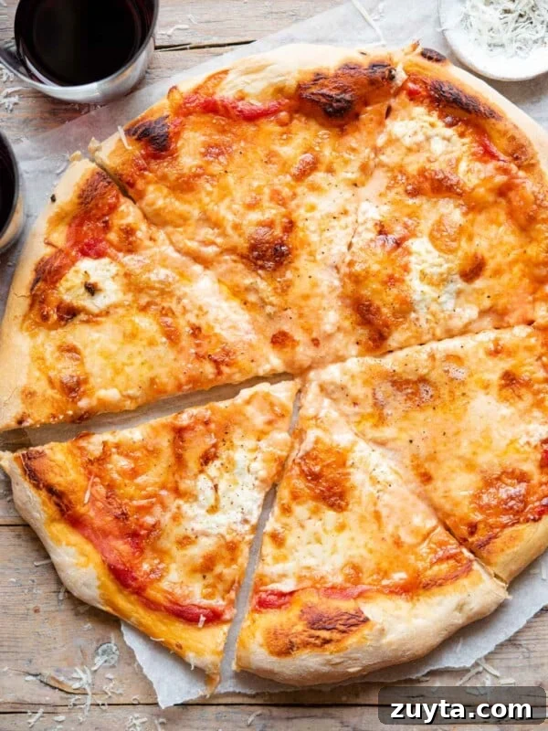 An overhead shot of a four cheese pizza cut into slices