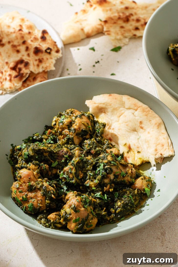 Creamy Chicken Saag with Spinach 2 A blue bowl with Palak Chicken and naan ready to be eaten.