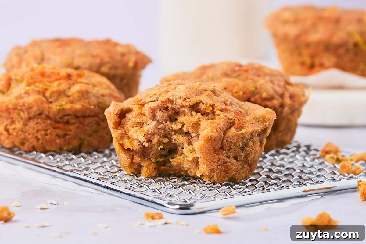 One-Bowl Zucchini Carrot Muffins Recipe 8 zucchini carrot oat muffin with a bite taken out of it.