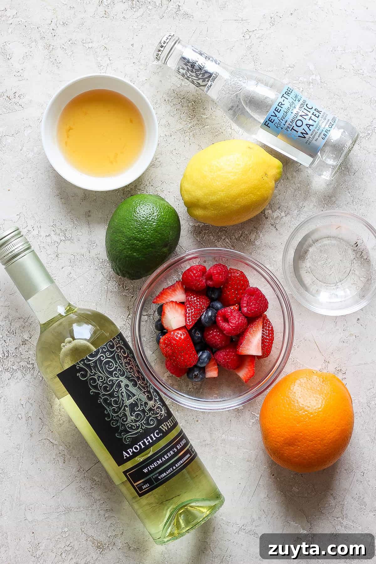 White Sangria Recipe with Citrus and Fresh Berries 3 Ingredients for a white wine sangria on the counter.