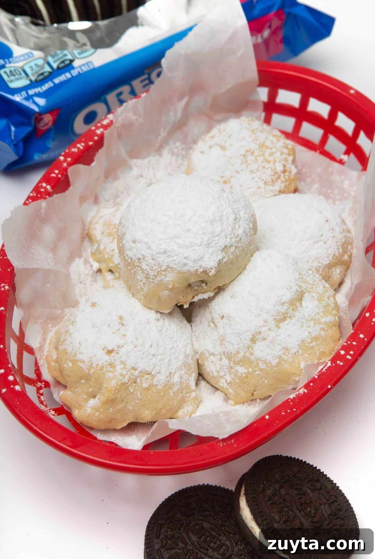 Air Fryer Oreos Recipe: Crispy, Gooey Dessert 3 air fried oreos in red basket sprinkled with powdered sugar
