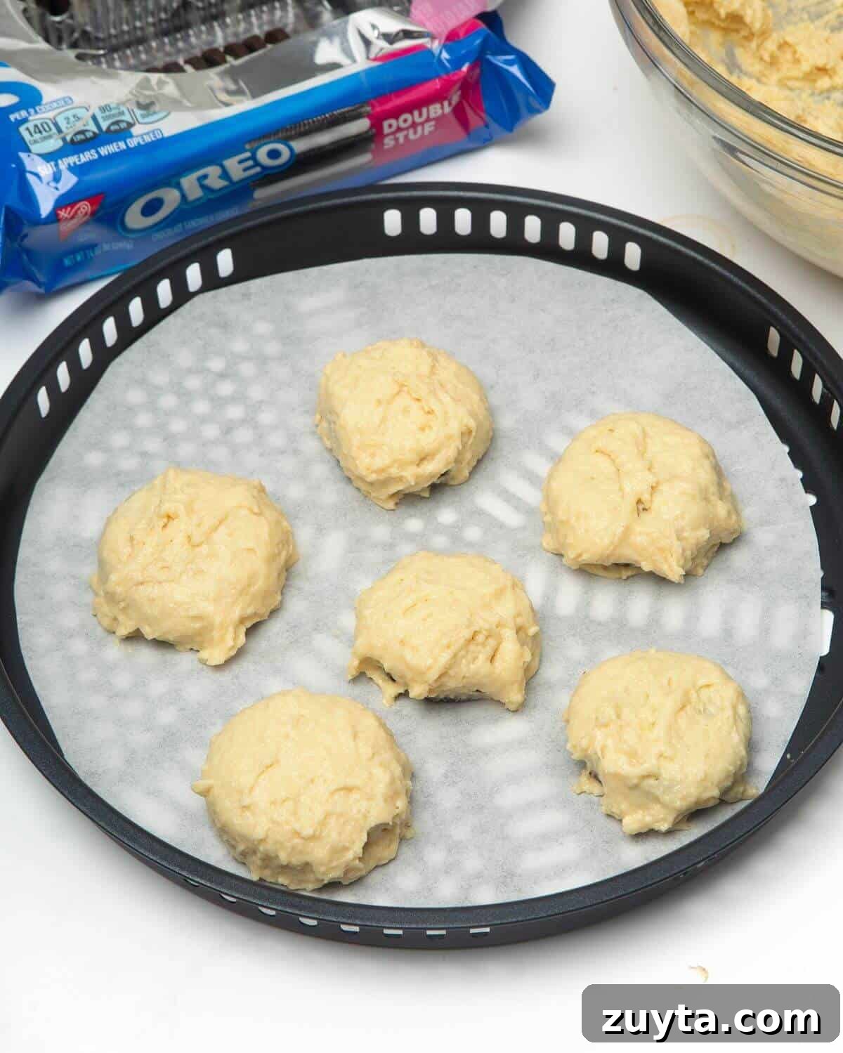 Air Fryer Oreos Recipe: Crispy, Gooey Dessert 9 oreos dipped in batter on air fryer tray lined with parchment paper