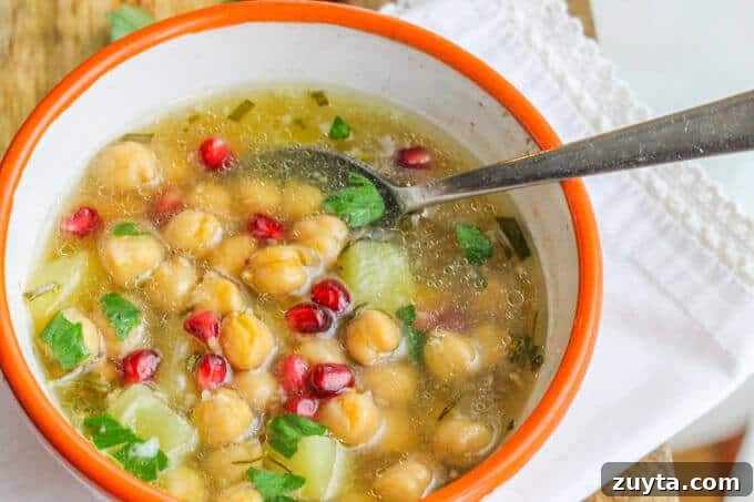 Greek Chickpea Soup ('Revithosoupa') is a traditional Greek vegan soup that uses simple ingredients. This version uses canned chickpeas and is ready in 20 minutes. Greek Chickpea Soup (Revithosoupa) with pomegranates in a bowl with spoon