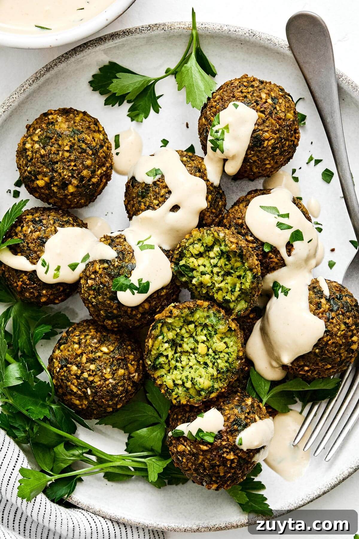 Over 60 Mediterranean Diet Recipes for Every Meal 3 Falafels with tahini sauce and a fork.