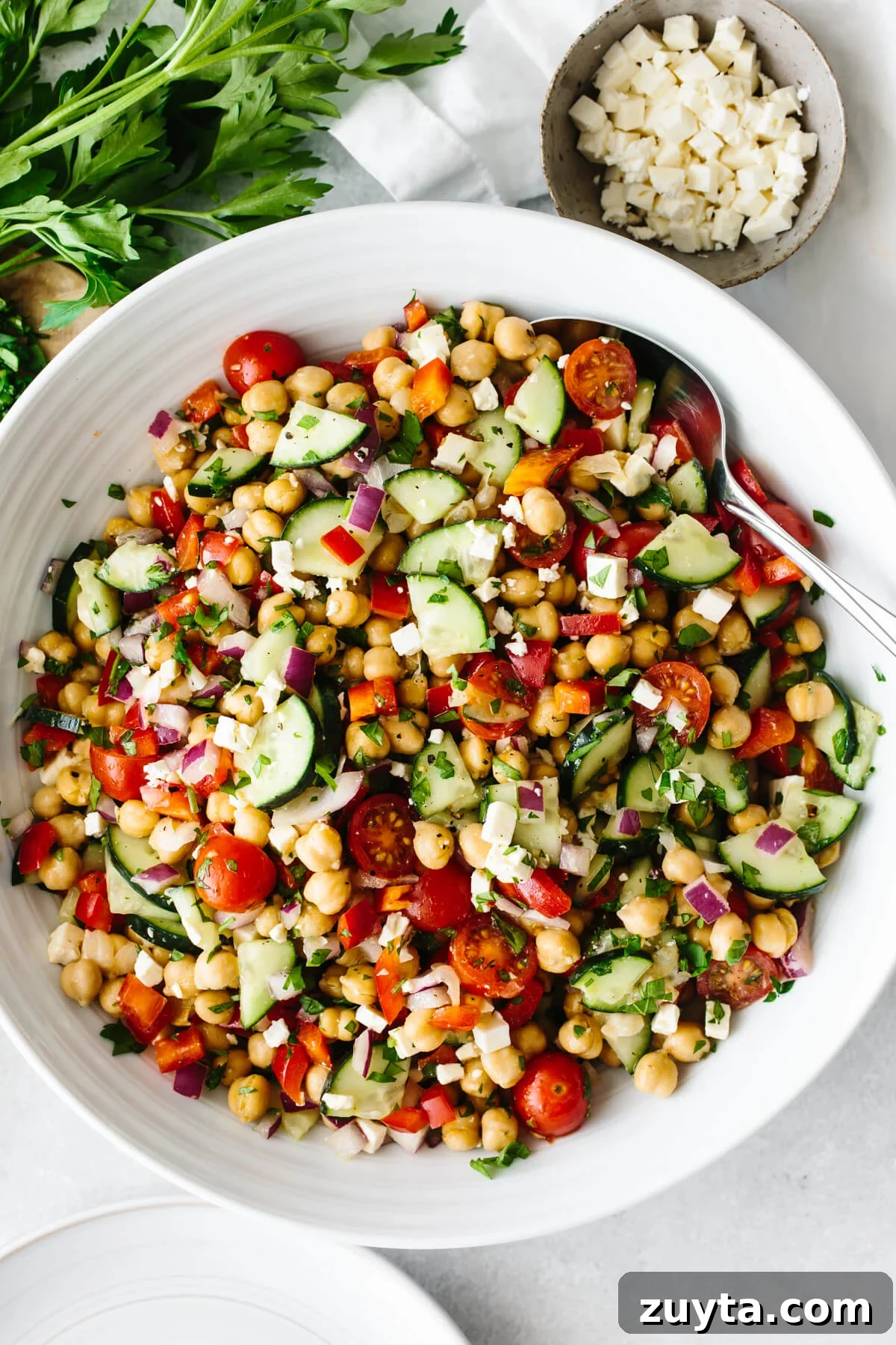 Over 60 Mediterranean Diet Recipes for Every Meal 23 Mediterranean chickpea salad in a large white bowl on a table.