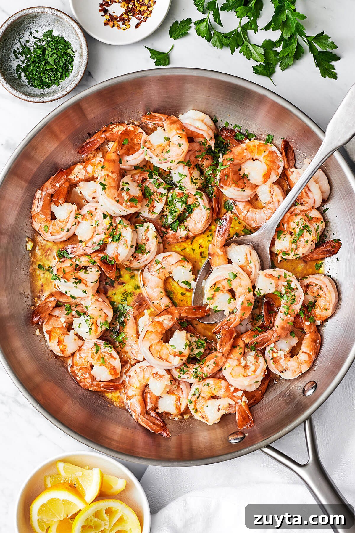 Over 60 Mediterranean Diet Recipes for Every Meal 4 Shrimp scampi in a large pan with a spoon