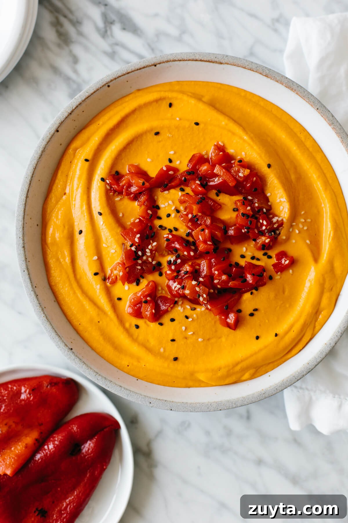 Over 60 Mediterranean Diet Recipes for Every Meal 34 A bowl of roasted red pepper hummus.