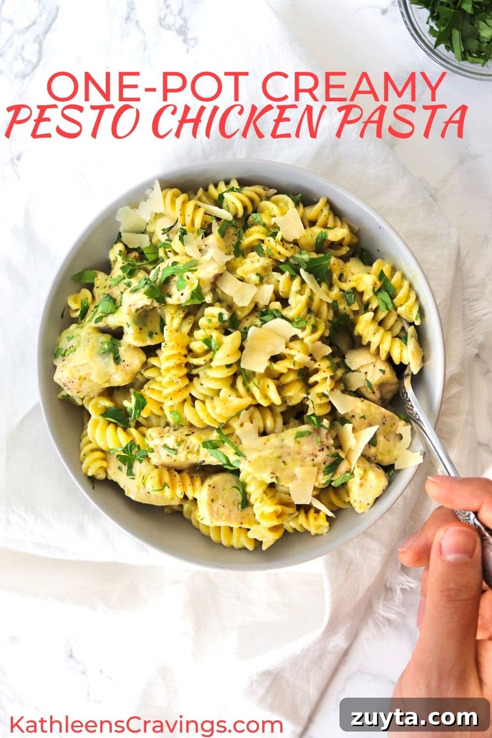 One-Pot Creamy Pesto Chicken Pasta Recipe 2 creamy pesto chicken pasta in a bowl with a fork and parsley