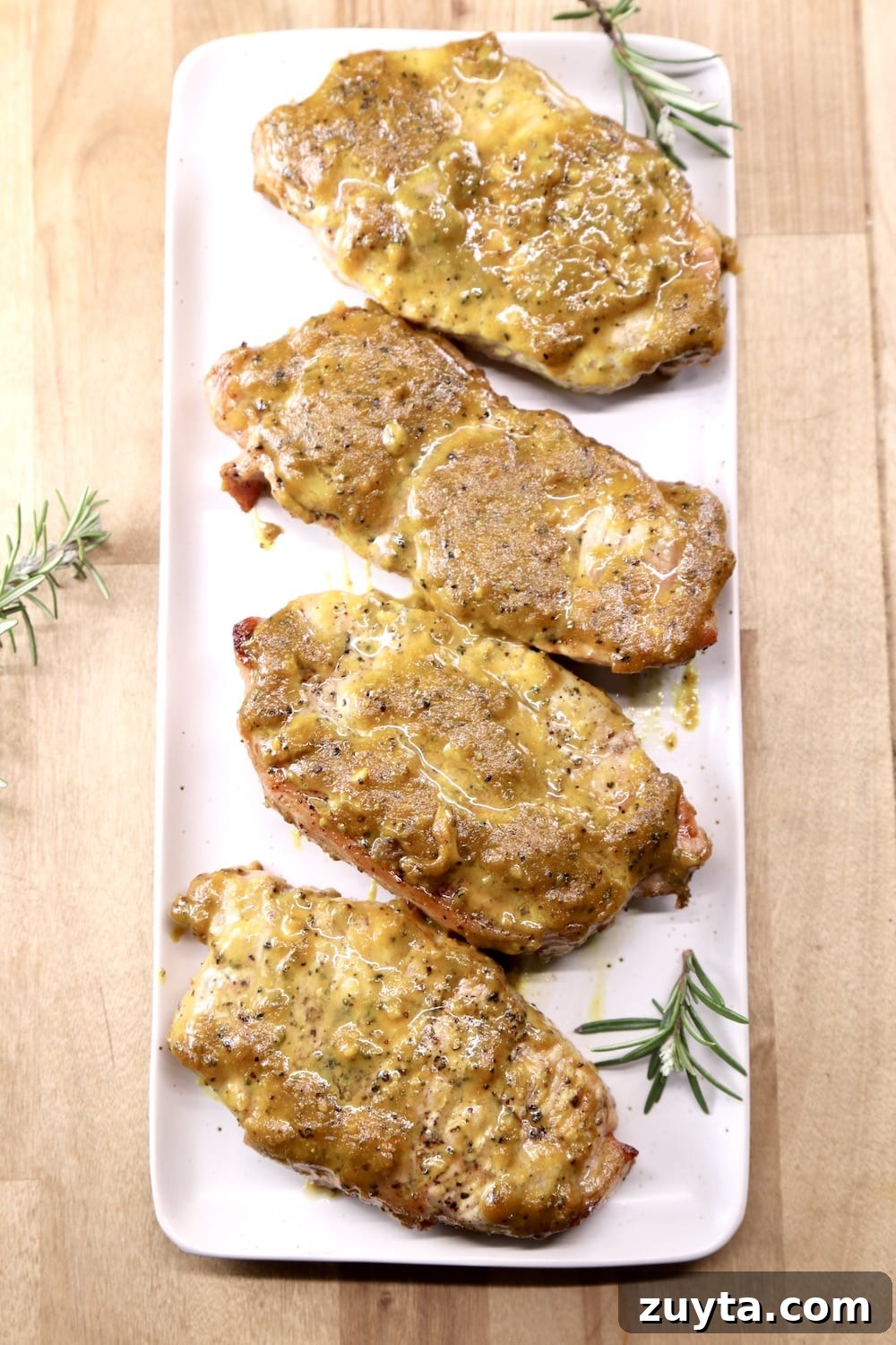 grilled pork chops with rosemary mustard sauce platter of 4 rosemary mustard pork chops with rosemary garnish