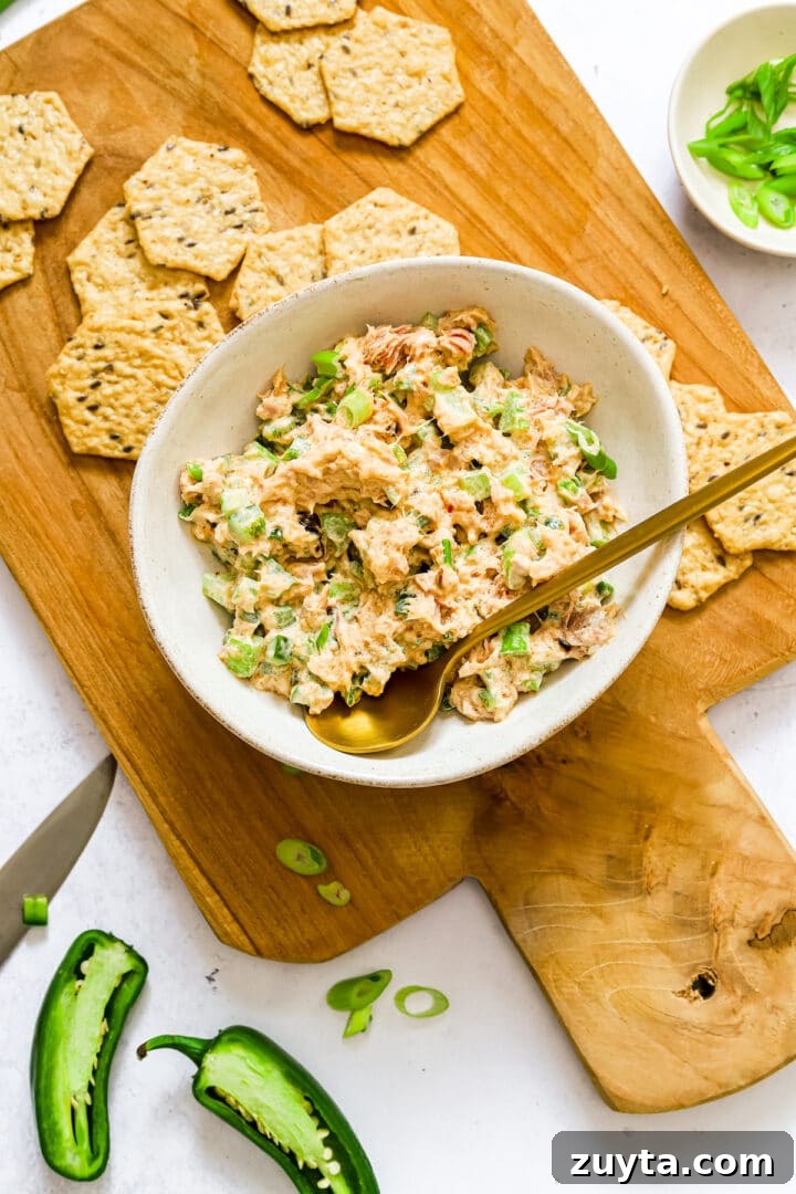 Spicy tuna salad in a white bowl with a gold spoon