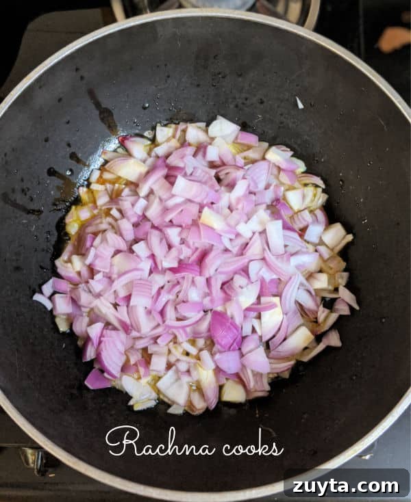 Mangalorean Prawn Gassi: Authentic Coconut Prawn Curry 5 Chopped onions being fried in a pan.