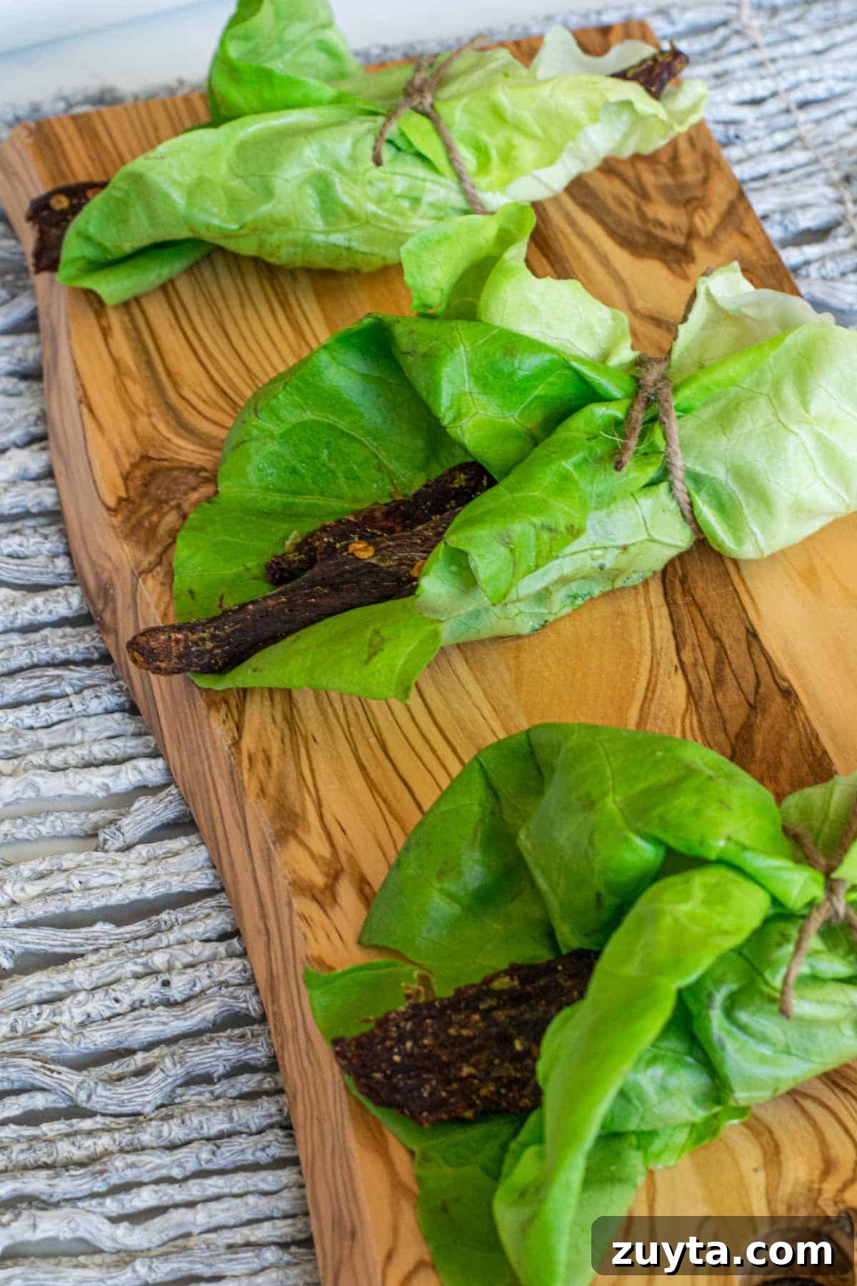 Homemade Asian-Spiced Venison Jerky Recipe 2 Deer jerky in lettuce wrap on cutting board