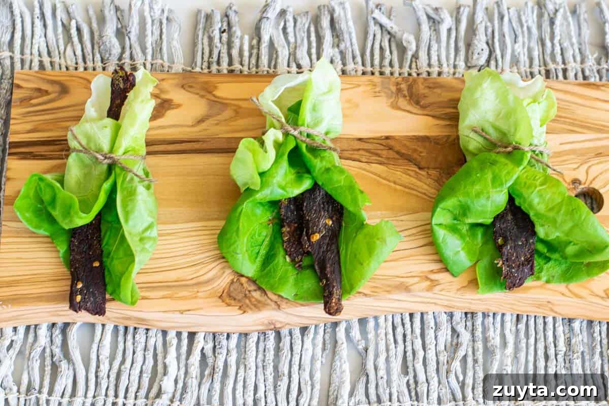 Homemade Asian-Spiced Venison Jerky Recipe 8 venison jerky in lettuce wraps on cutting board