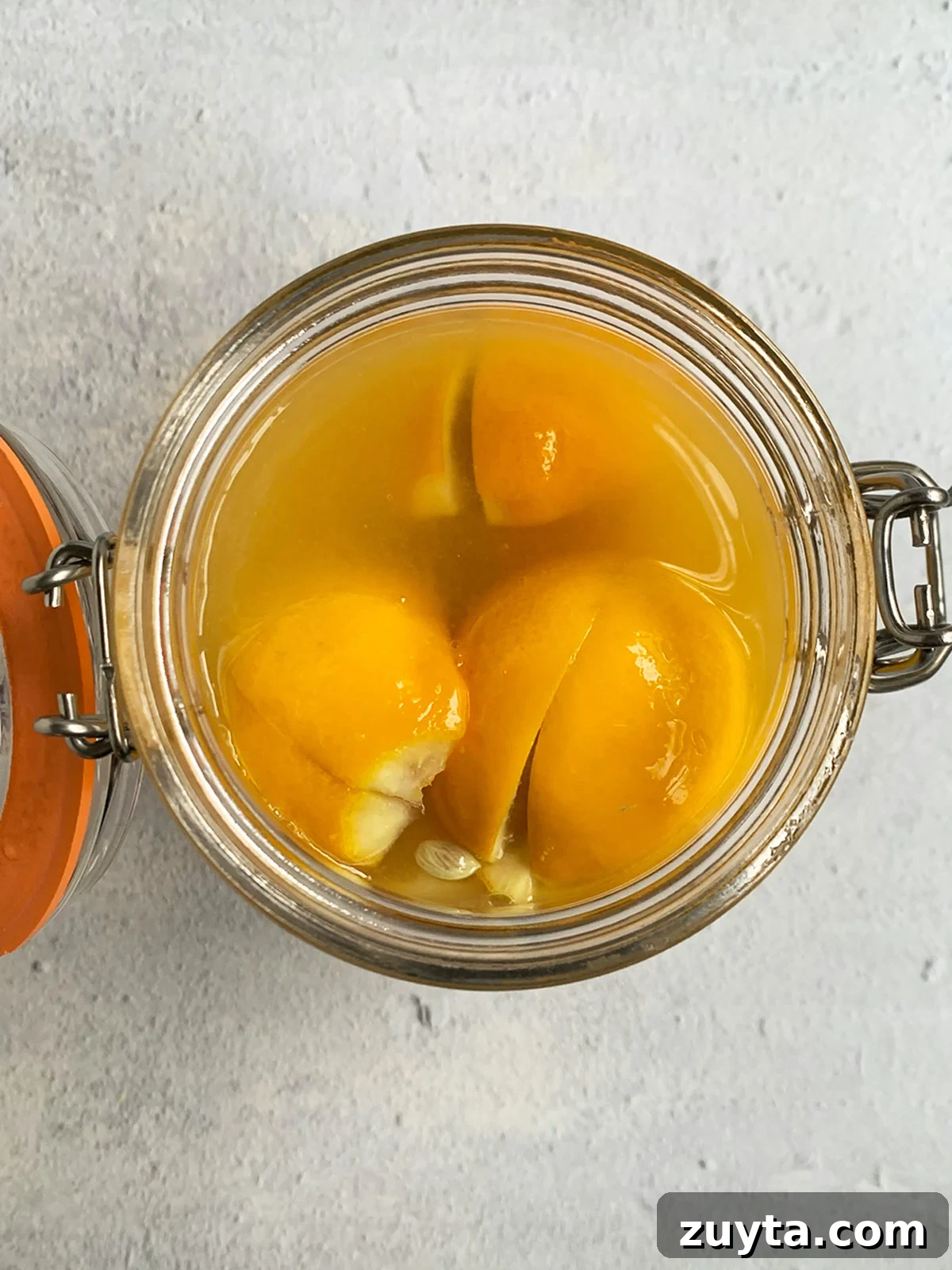 How to Make Preserved Lemons: Traditional Moroccan Recipe 9 Top down view of open jar of lemons ready to have olive oil added and be placed in the refrigerator.