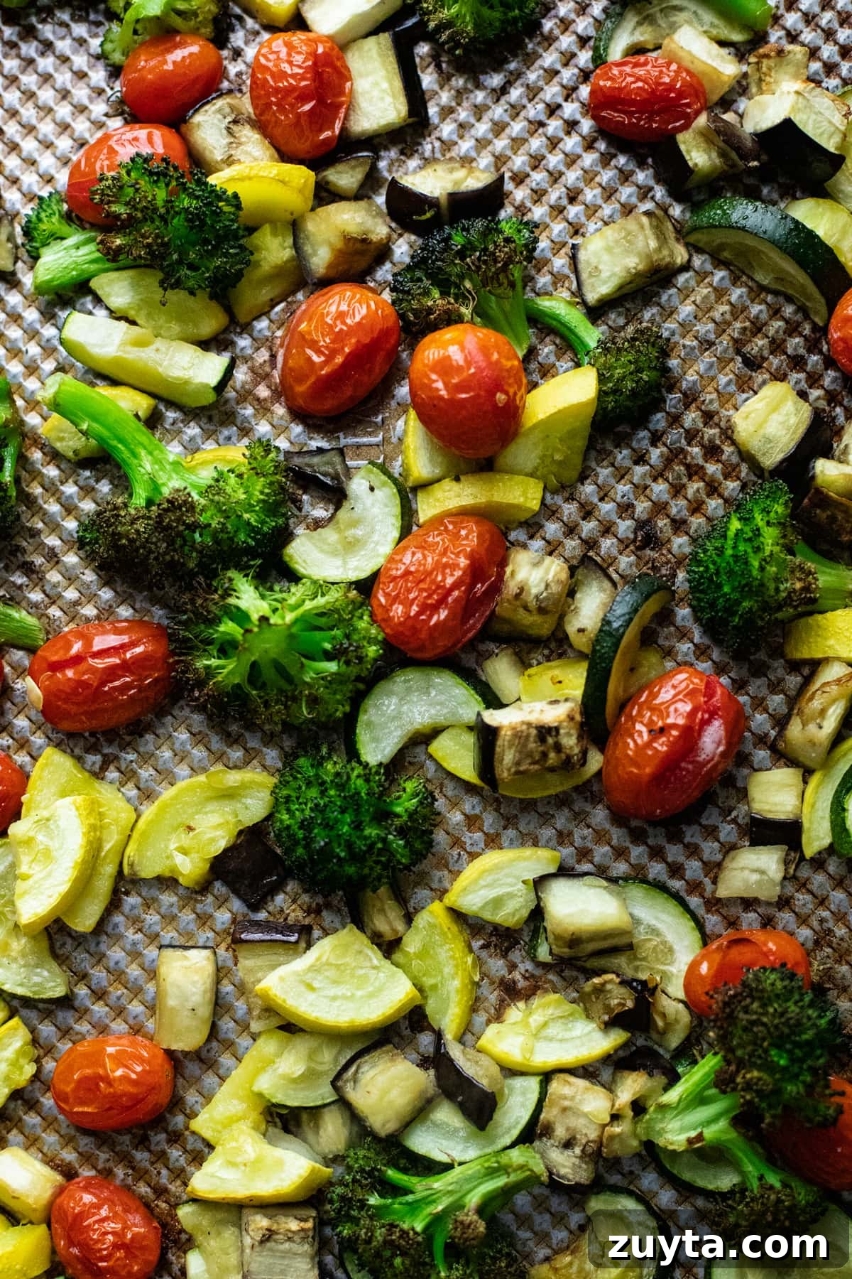 assorted roasted vegetables arranged on sheet pan.