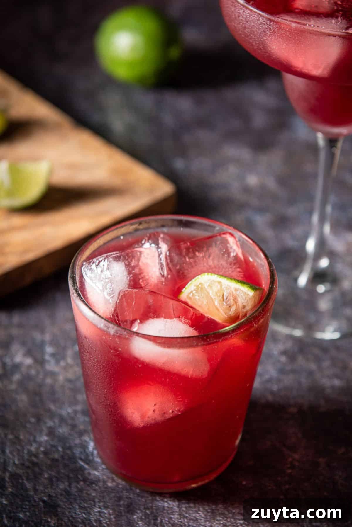 Pomegranate Margarita Cocktail Recipe 2 Close-up of the top of the pomegranate margarita in a short glass. There is a wedge of lime in it