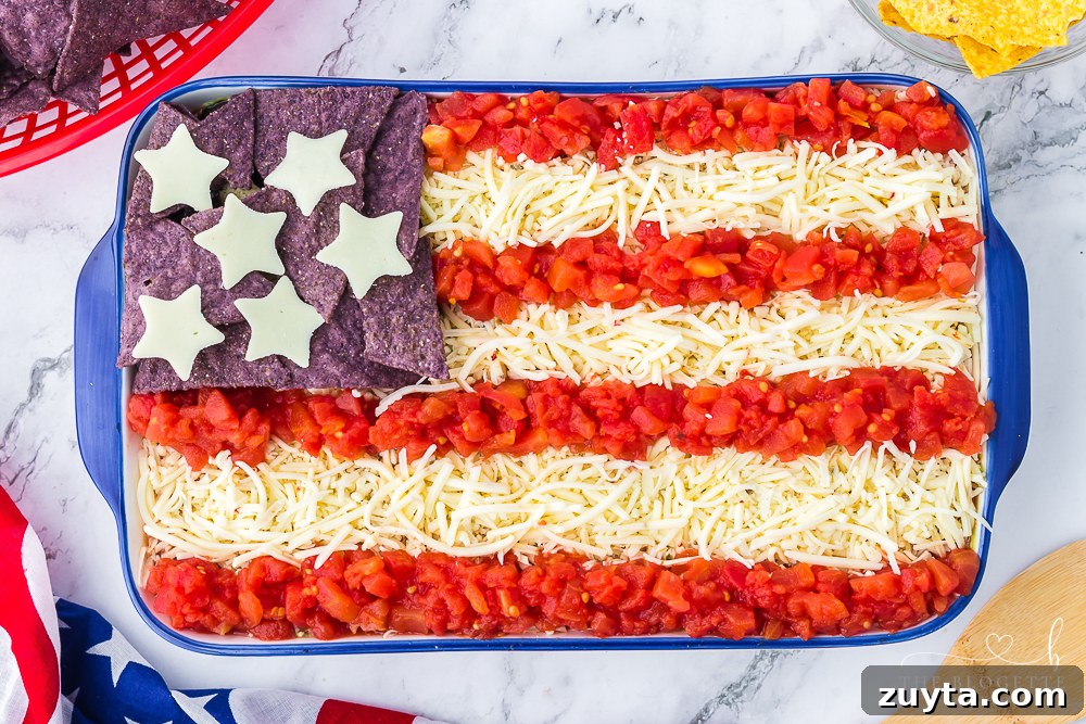 Patriotic American Flag 7 Layer Dip for Fourth of July 13 American Flag 7-Layer Dip! One of everyone's favorite 4th of July appetizers! A taco dip filled with beans, guacamole, salsa, and sour cream.
