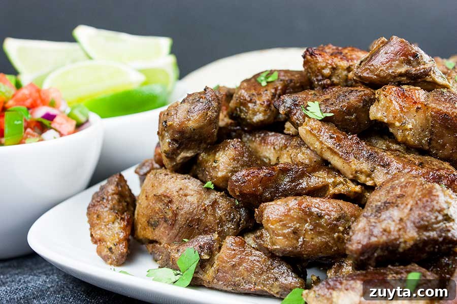 Slow-Braised Apple Cider Pork Shoulder 12 Crispy pork carnitas on a white platter garnished with chopped cilantro.