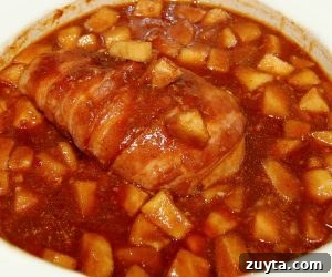 Cooked bacon-wrapped chicken in sauce