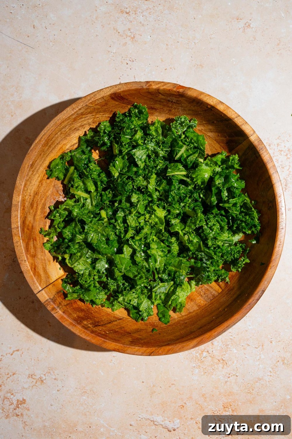 Sam's Club Copycat Mediterranean Pasta Salad Recipe 5 A salad bowl with chopped kale. The bowl is on a tan counter.