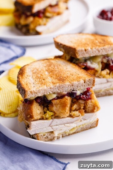 Half a leftover turkey sandwich with turkey, gravy, stuffing, and cranberry sauce.