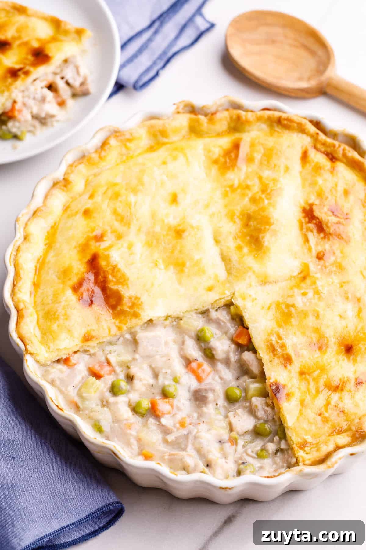 top down image of turkey pot pie with a quarter of the pie crust removed to show the inside of the pie