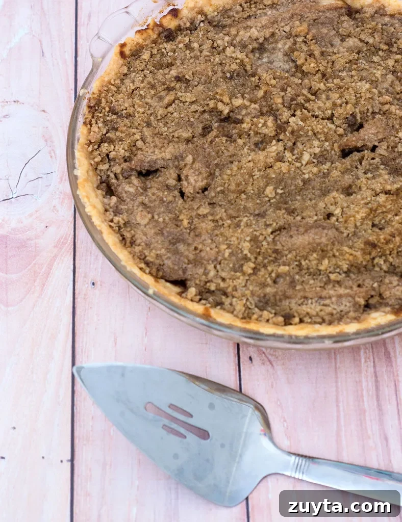 Rustic Pear Pie with Hazelnut Crumble 3 Pear pie with hazelnut crumb topping, close-up showing crumb texture and toasted nuts.