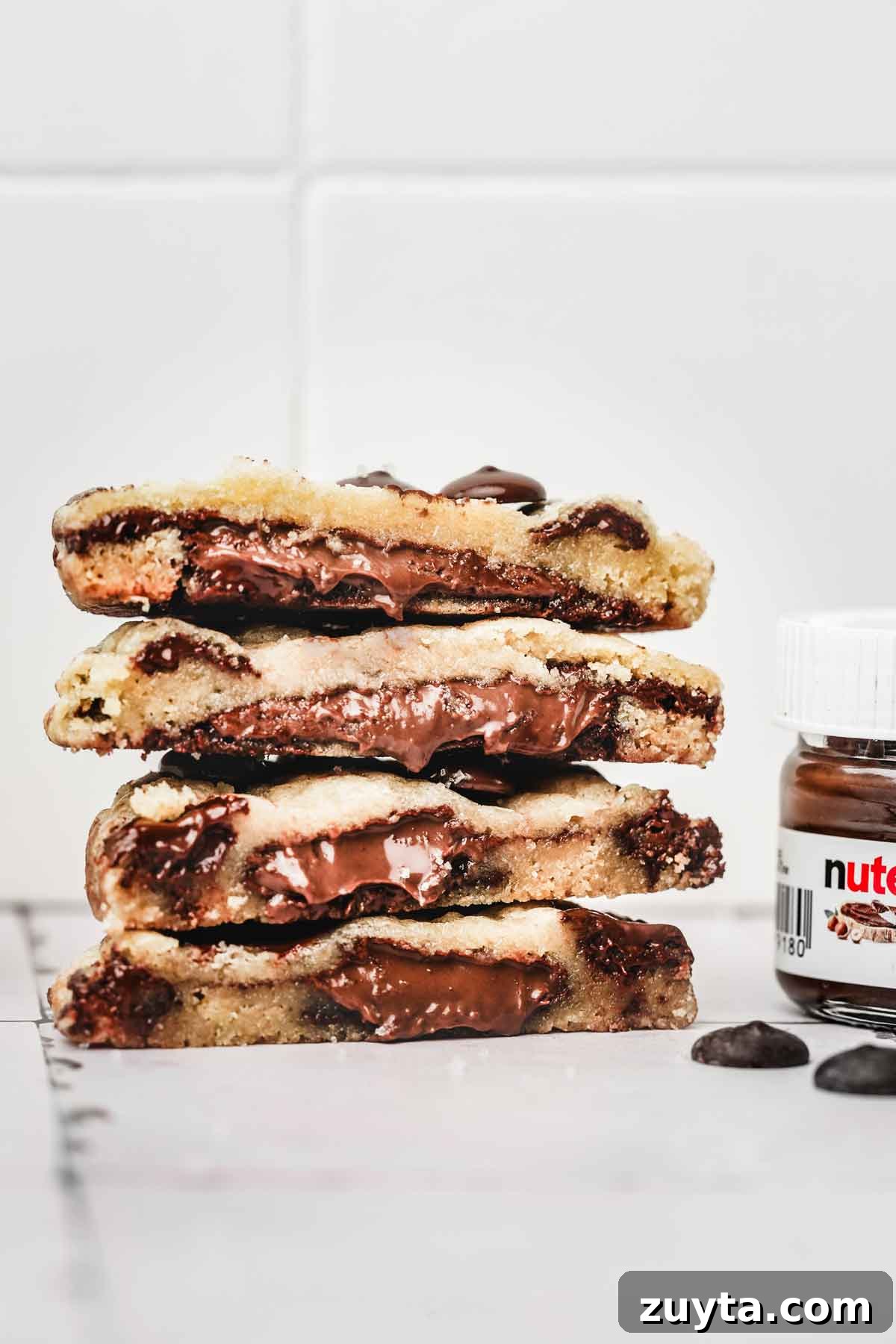 Stack of Nutella stuffed chocolate chip cookies showing gooey center