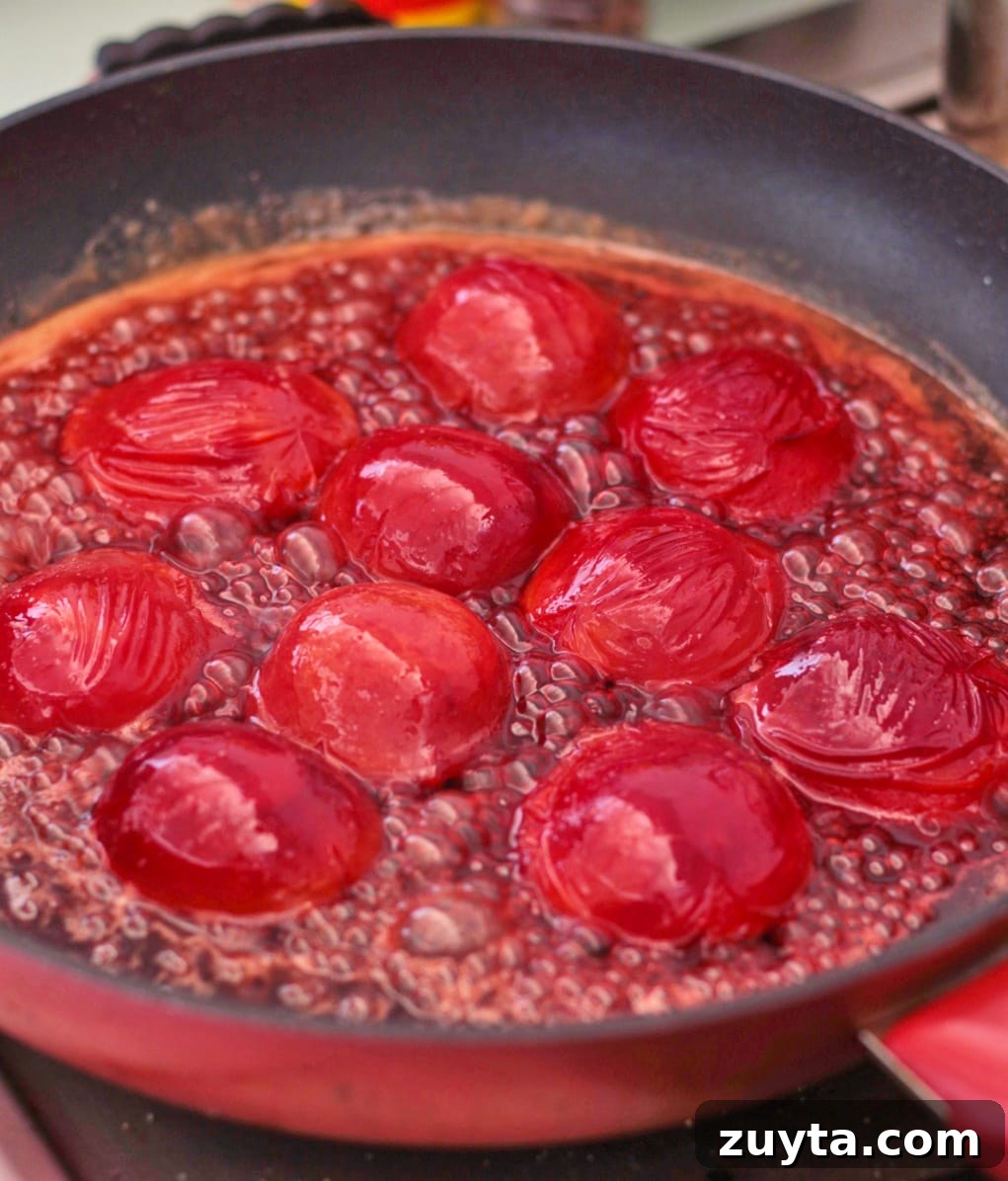 Caramelized Plum Upside-Down Cake Recipe 4 Plums caramelising in a pan.