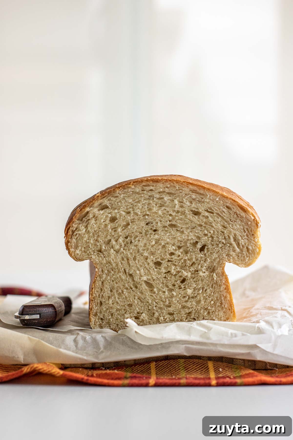 Make Sourdough Sandwich Bread in One Day 2 Same Day Sourdough sandwich bread on a wooden board, fluffy interior showing.