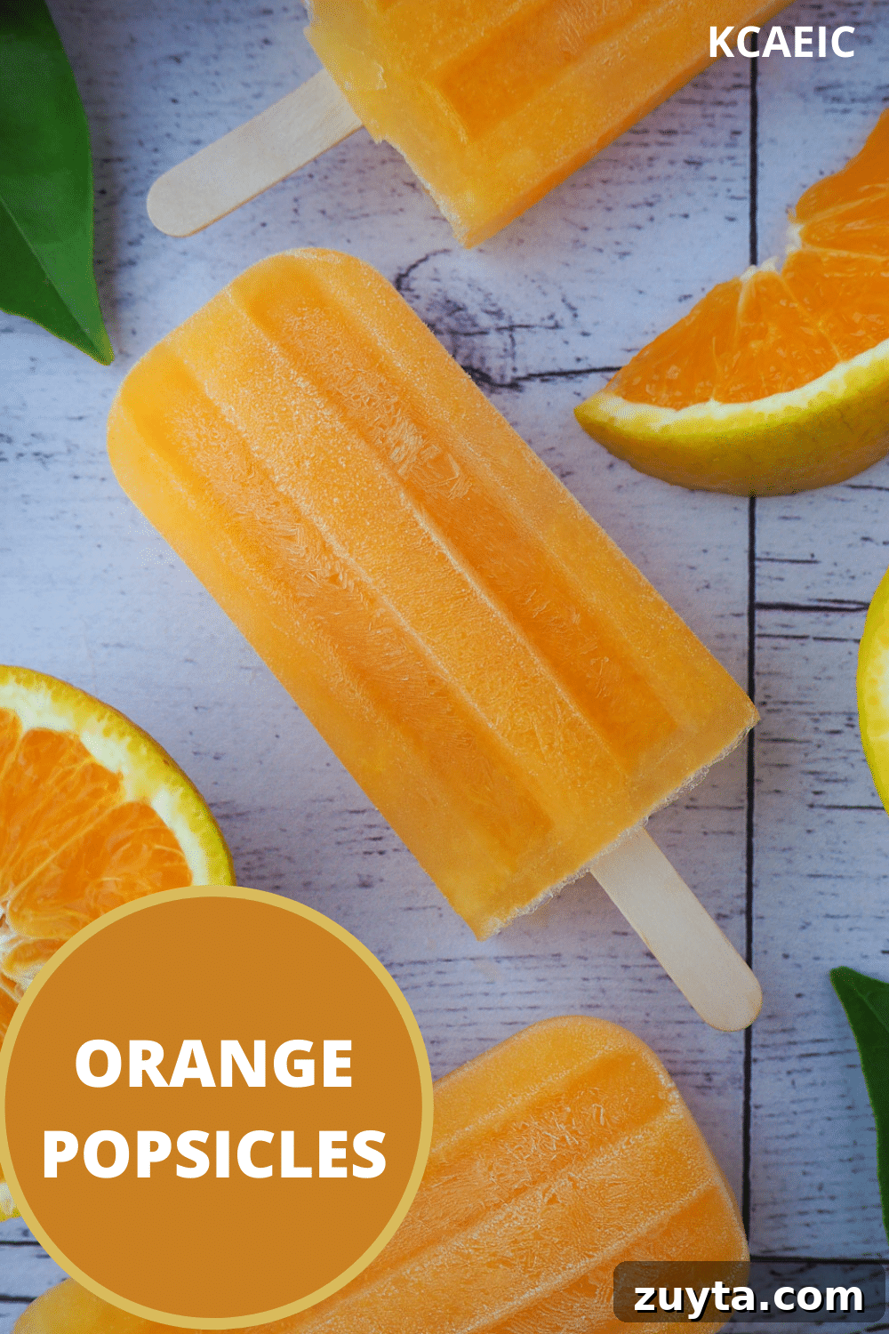 Homemade Orange Popsicles Recipe 10 Orange popsicles in a vertical row, with fresh orange and orange leaves and text overlay, orange popsicles, KCAEIC.