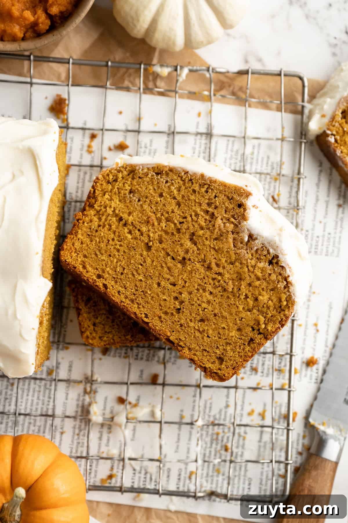 Slices of pumpkin bread with cream cheese frosting stacked on cooling rack Slices of pumpkin bread with cream cheese frosting stacked on cooling rack