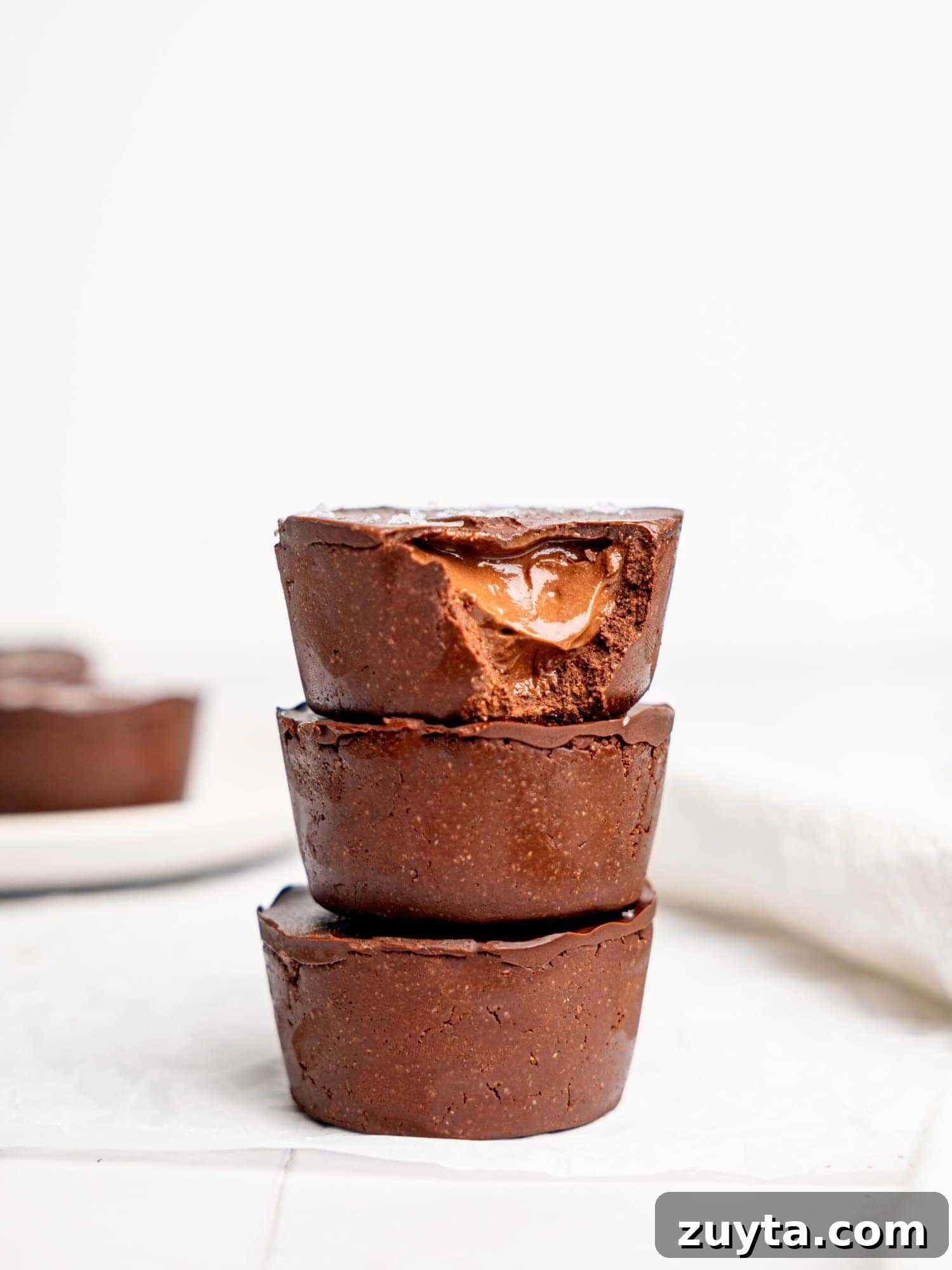12 No-Bake Dessert Recipes for Parties and Weeknights 10 Three mini triple chocolate cheesecakes stacked on top of each other.