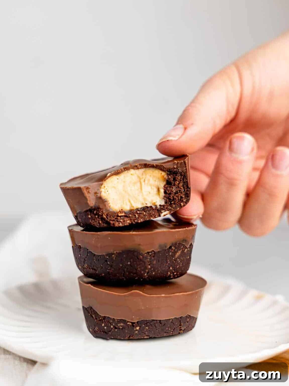12 No-Bake Dessert Recipes for Parties and Weeknights 12 Three chocolate peanut butter cheesecakes stacked on top of each other on a white plate.