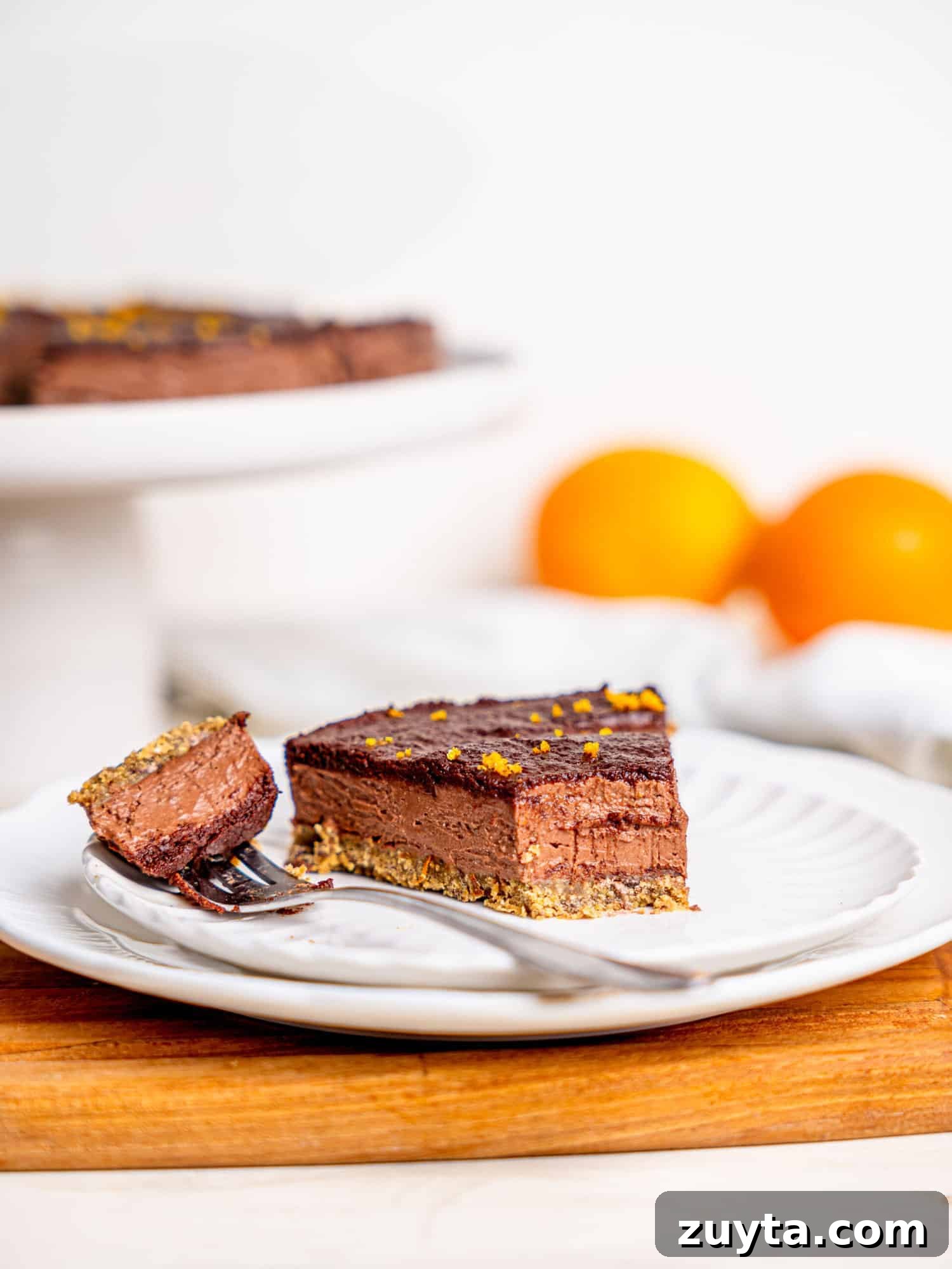 12 No-Bake Dessert Recipes for Parties and Weeknights 2 A slice of chocolate orange cheesecake on a white plate.