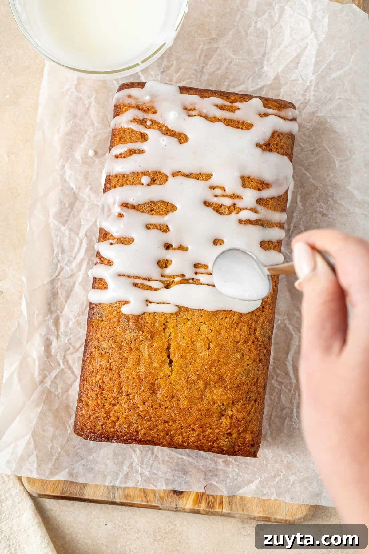 Lemon Pistachio Loaf Cake with Cardamom 9 Drizzling the lemon glaze over the cake.