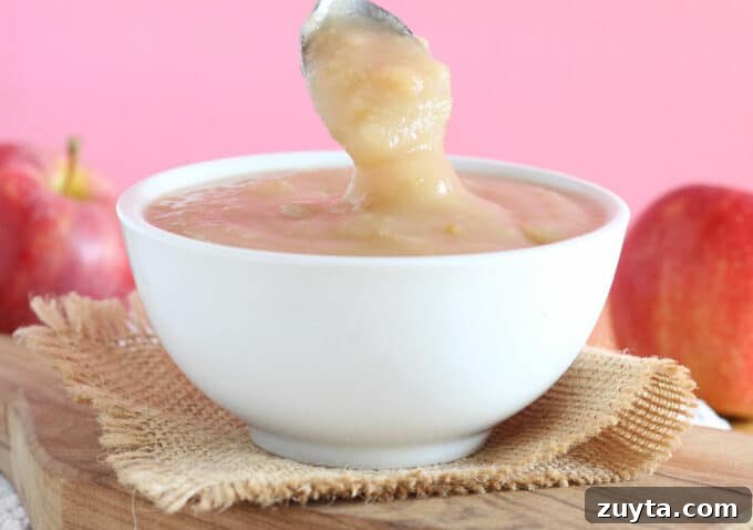 Homemade Instant Pot Applesauce Recipe 2 Applesauce being spooned out of a bowl.