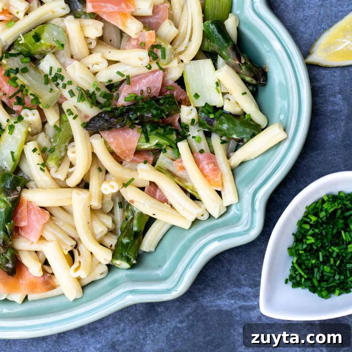Soy-Ginger Salmon Stir-Fry with Vegetables 14 close up of smoked salmon and asparagus pasta on platter with lemon wedge and small bowl of chives