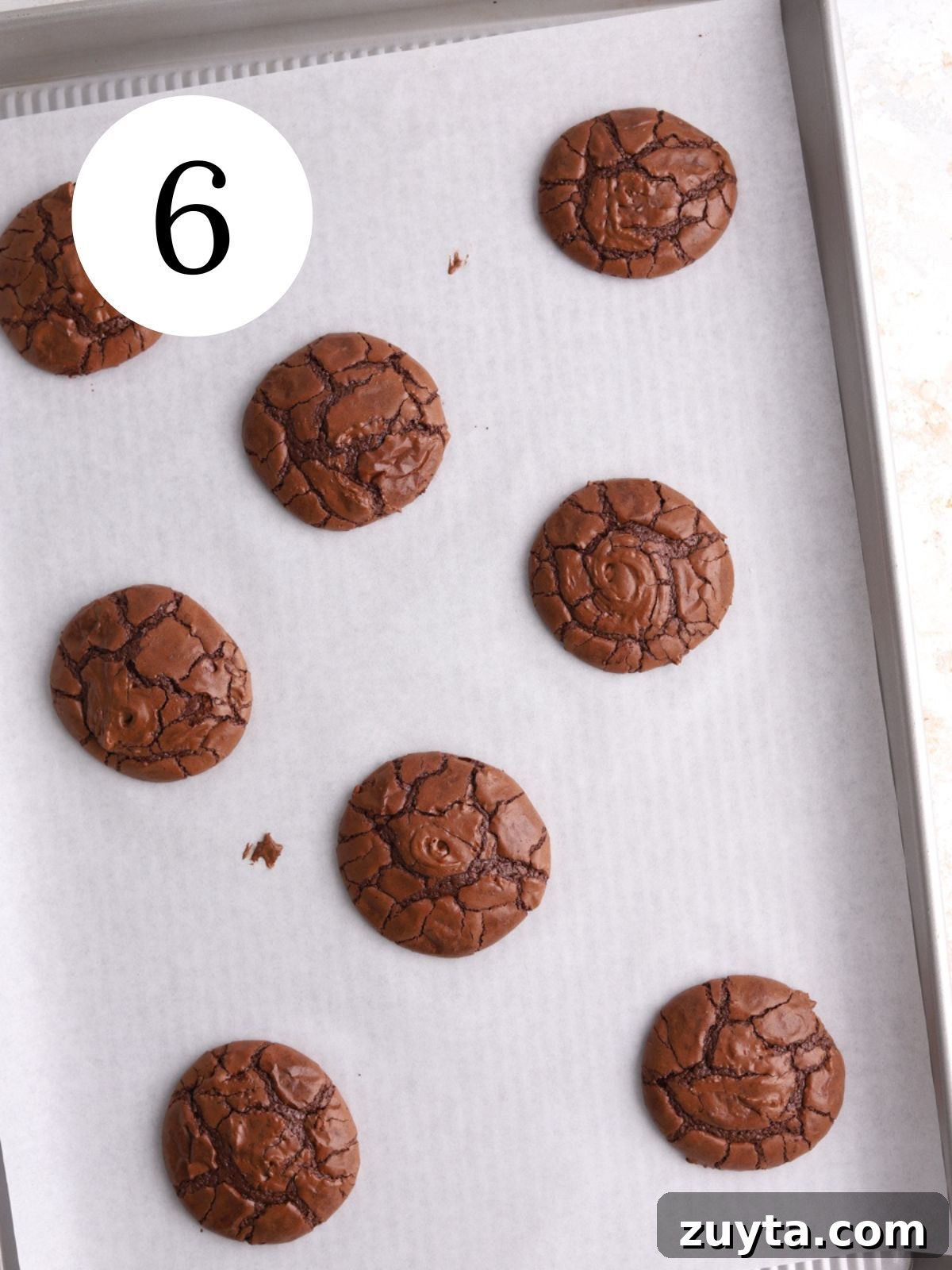 Fudgy Brownie Crinkle Cookies Recipe 6 Freshly baked crackle topped chocolate cookies on a baking sheet.