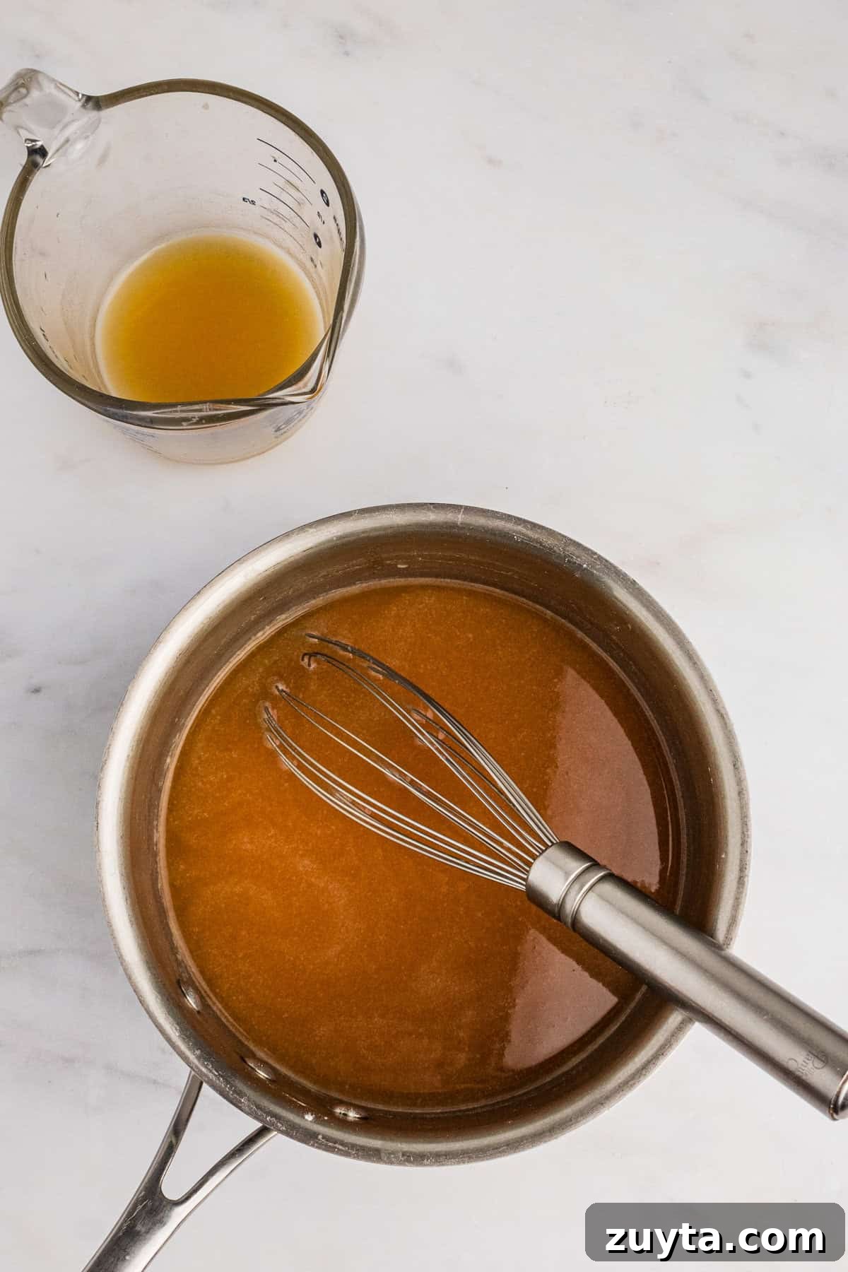 How to Make Turkey Gravy Without Drippings 6 Pot with broth added and wire whisk.