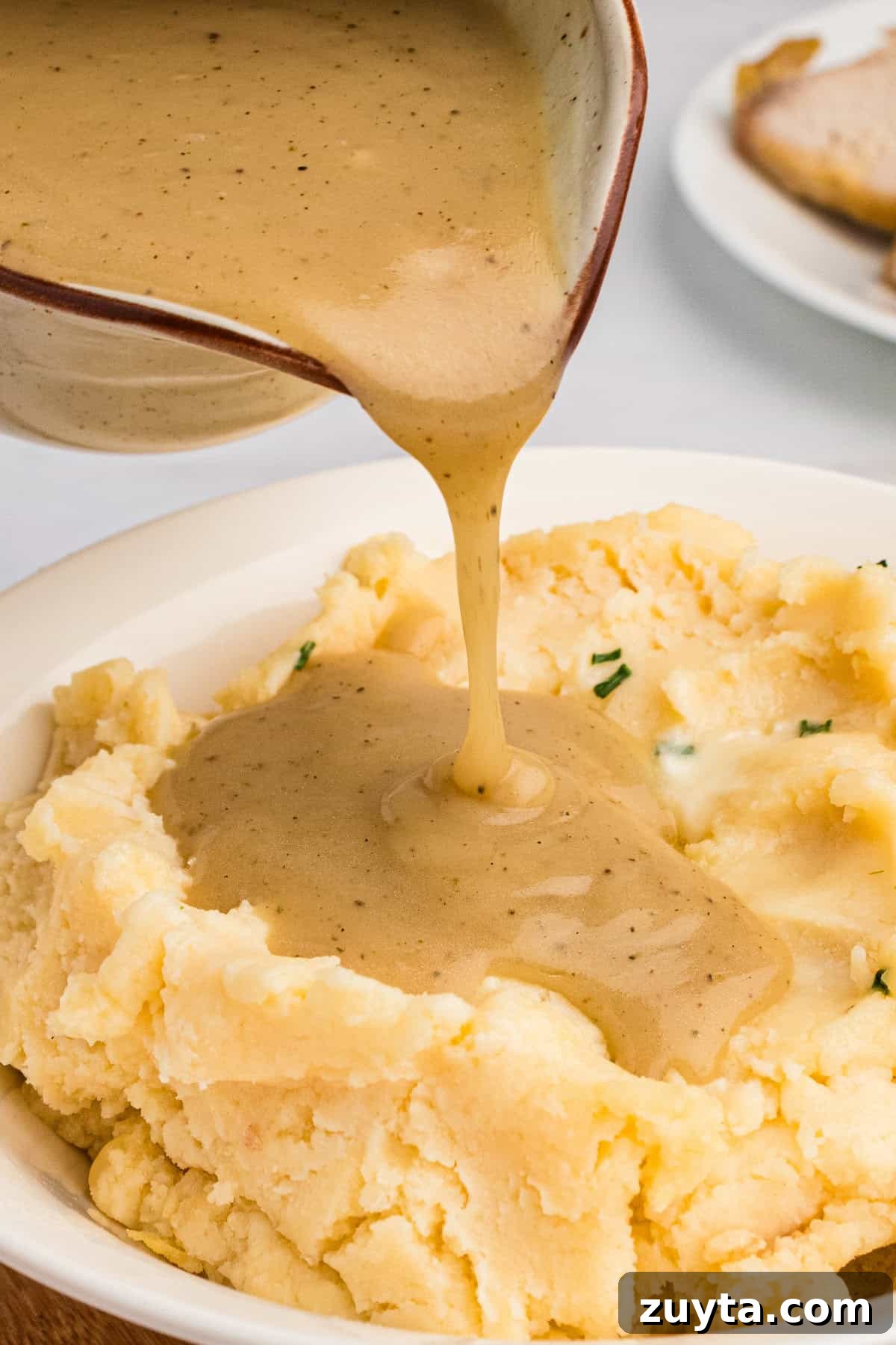 How to Make Turkey Gravy Without Drippings 10 Quick and easy homemade gravy being poured on mashed potatoes.