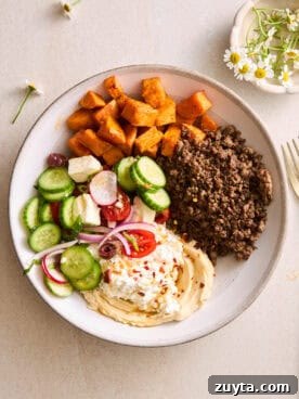 A ground beef bowl with roasted sweet potatoes, fresh veggies, and cottage cheese.