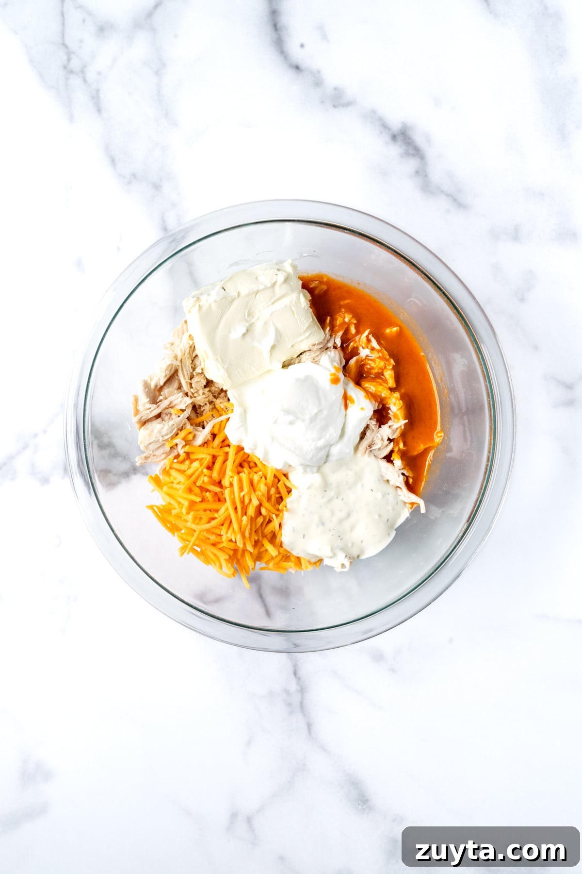 Creamy Buffalo Chicken Dip with Greek Yogurt 4 Greek Yogurt Buffalo Chicken Dip Ingredients in a Glass Mixing Bowl.