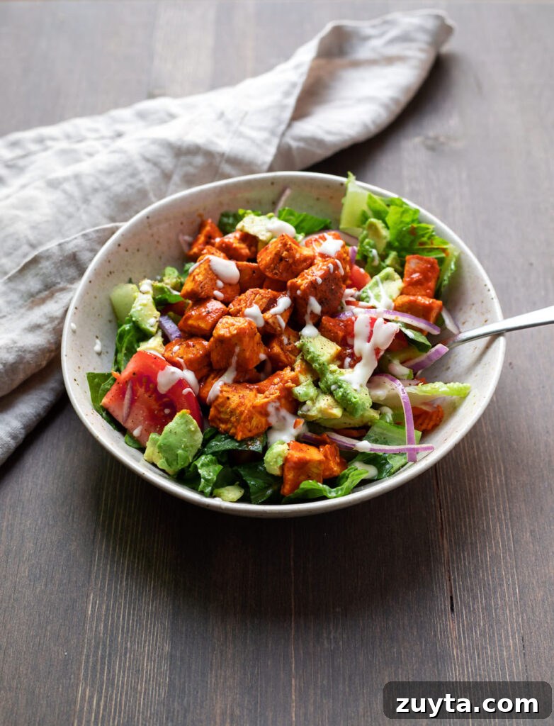 Plated buffalo chicken avocado salad with dressing