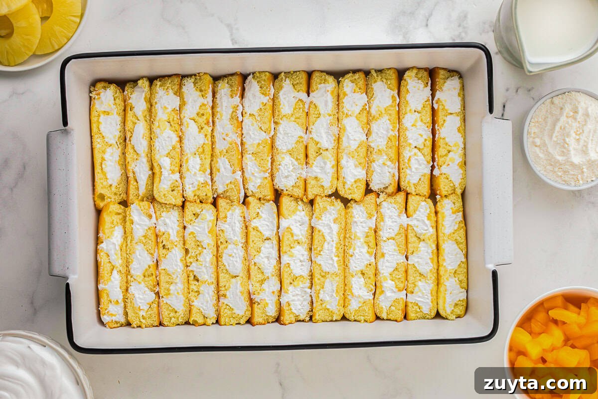 How to Make Twinkie Cake with Creamy Vanilla Filling 5 halved twinkies arranged filling-side-up in a baking pan.