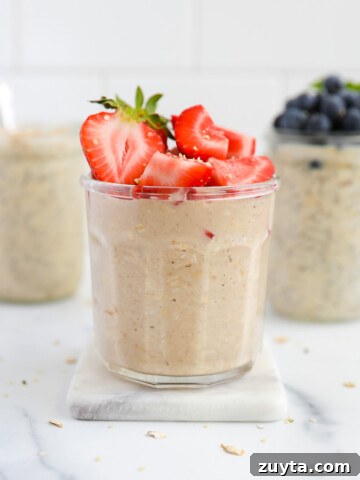 Three jars of overnight oats with berries on top of them