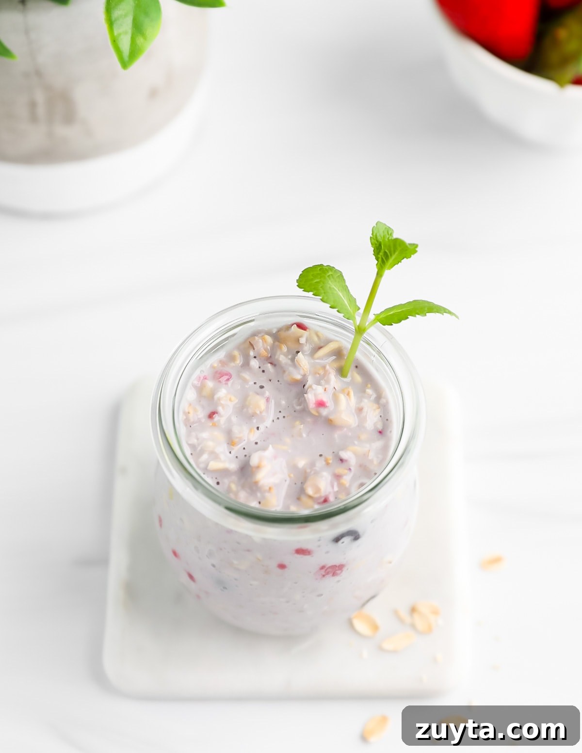 Creamy Overnight Oats with Frozen Fruit 6 An overhead image of a jar filled with overnight oats and a sprig of fresh mint.