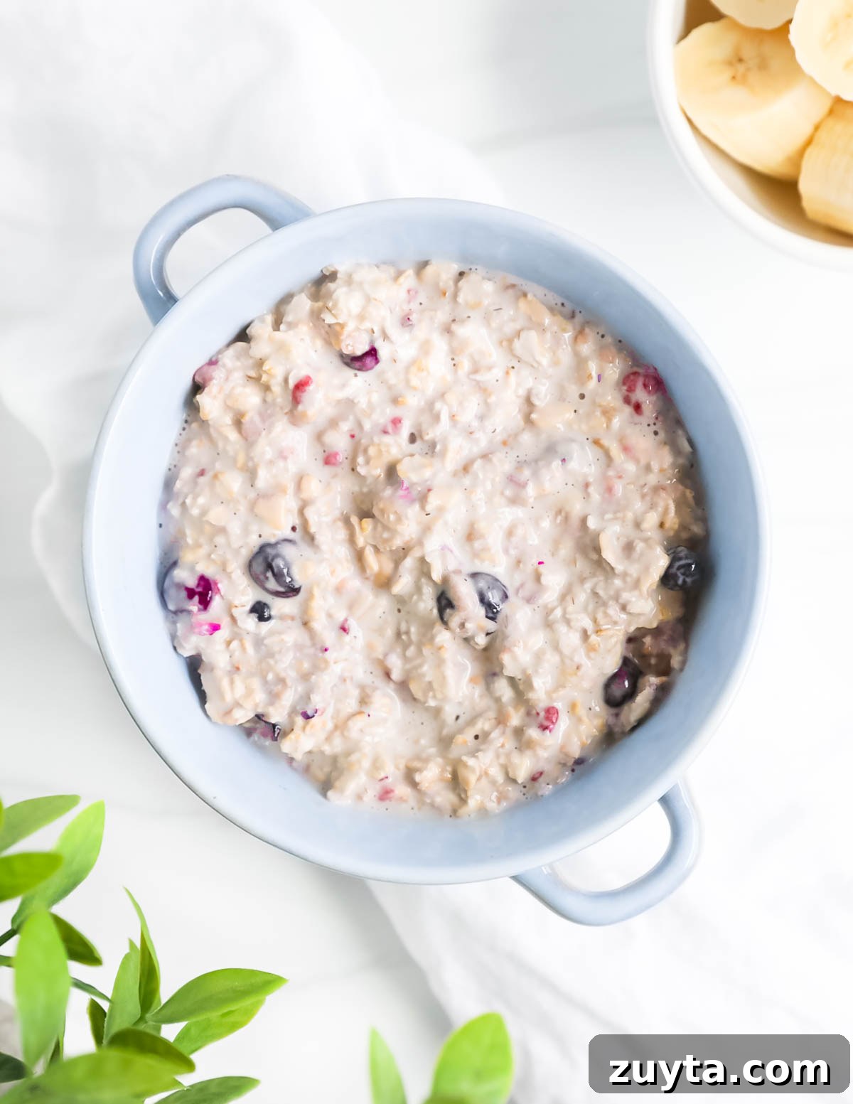 Creamy Overnight Oats with Frozen Fruit 7 An overhead image of a blue bowl that is filled with creamy oats and frozen berries.