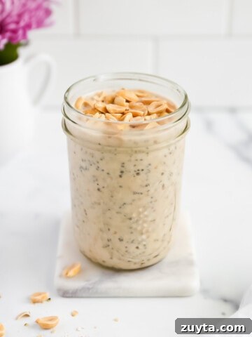 A jar filled with chia seeds and overnight oats with peanuts on top