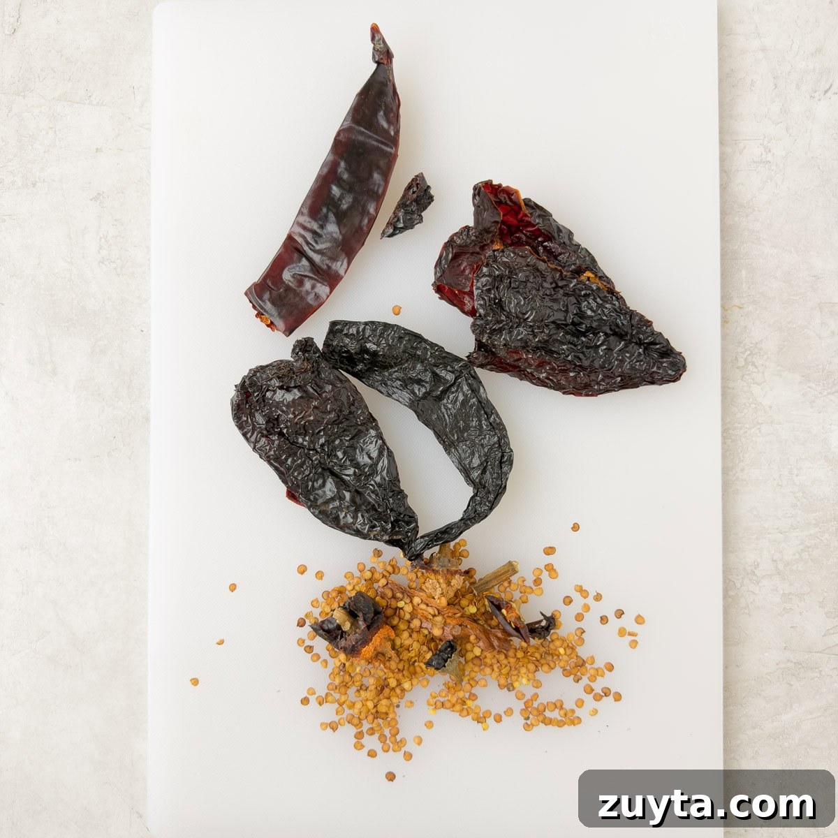 Removing seeds from dried chili peppers before making enchilada sauce.